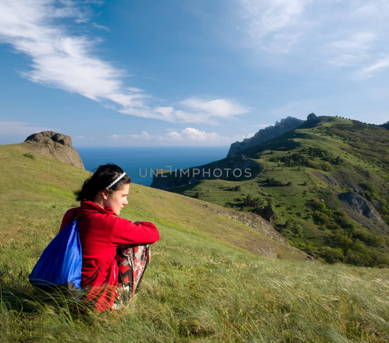 Woman sitting on a hill over sea