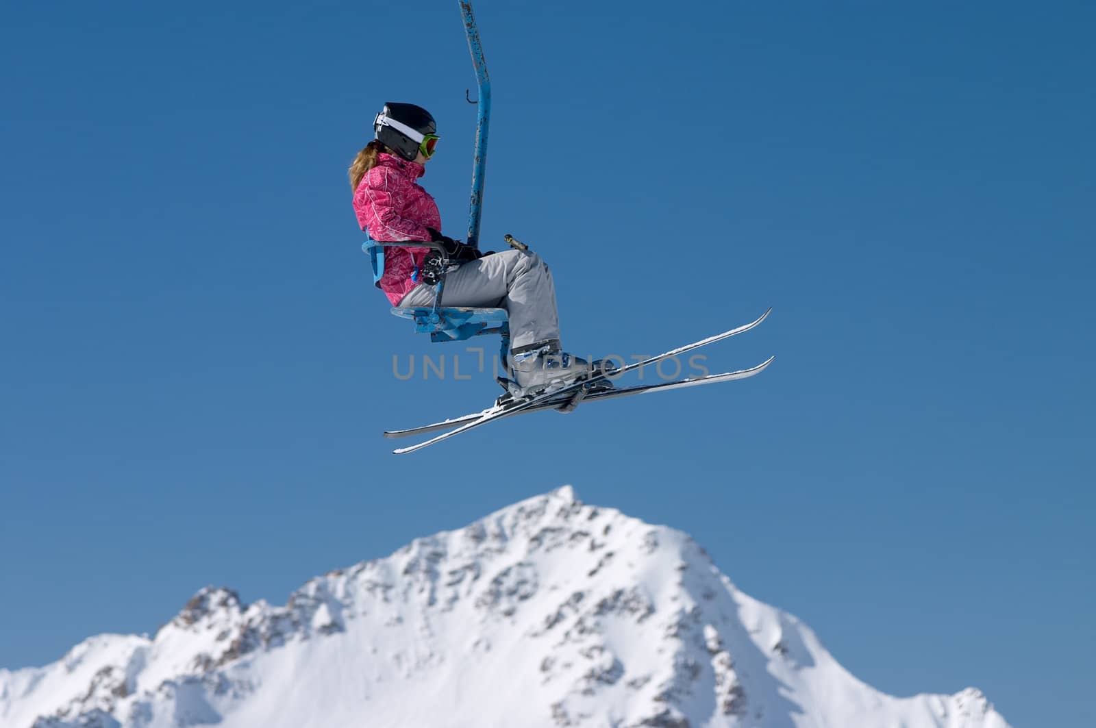 skier girl on ski lift under mountain