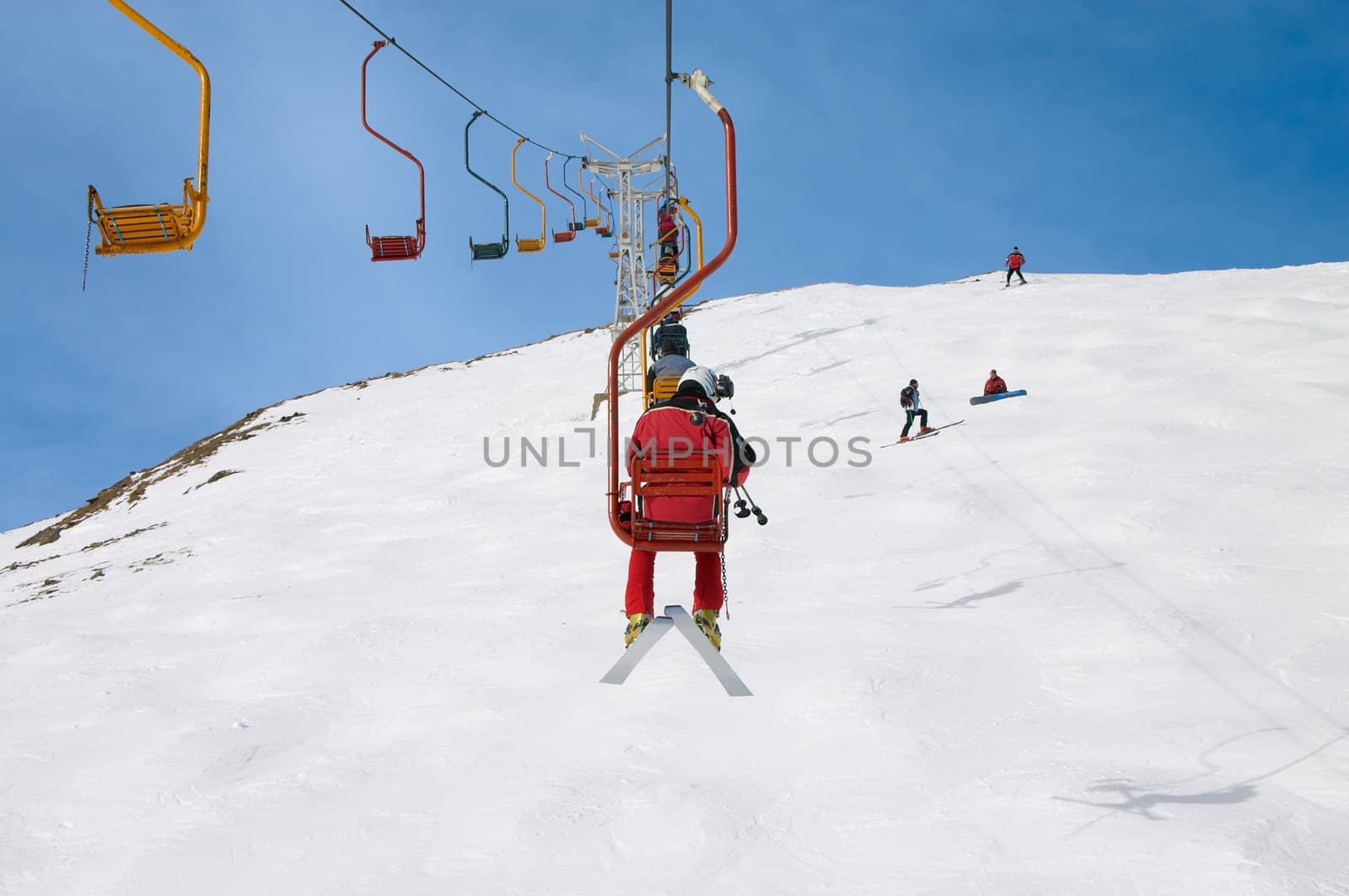 skiers on chair lift in the winter mountains