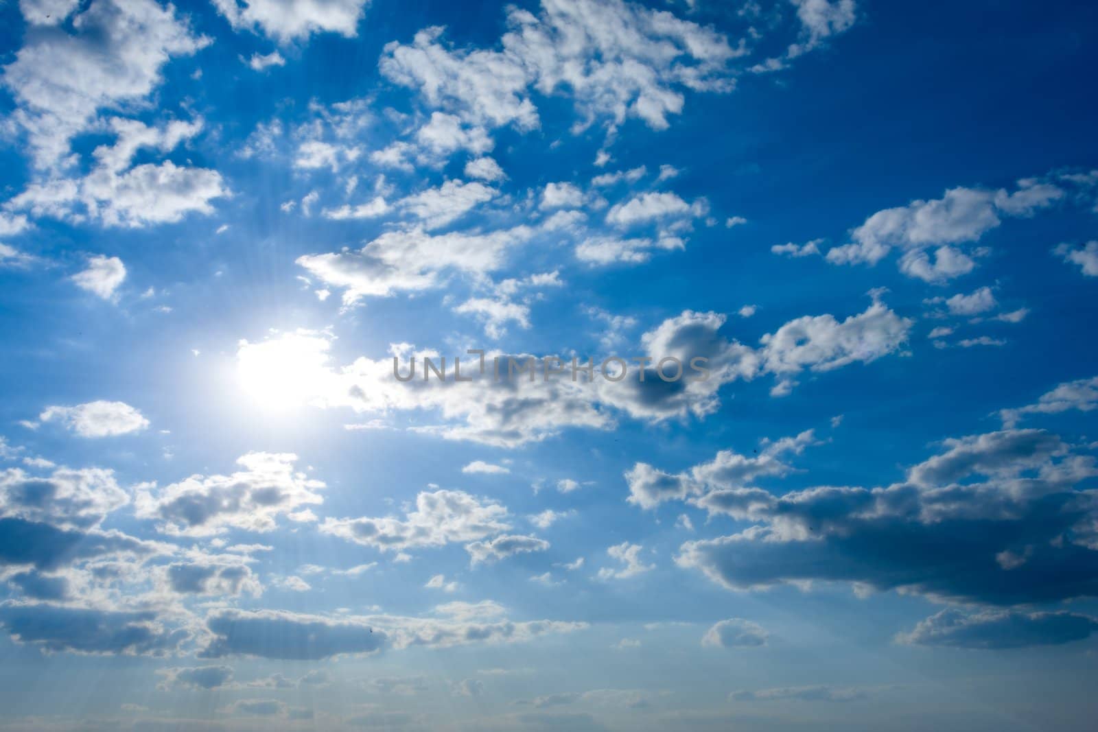 Cloudscape with sun in blue sky