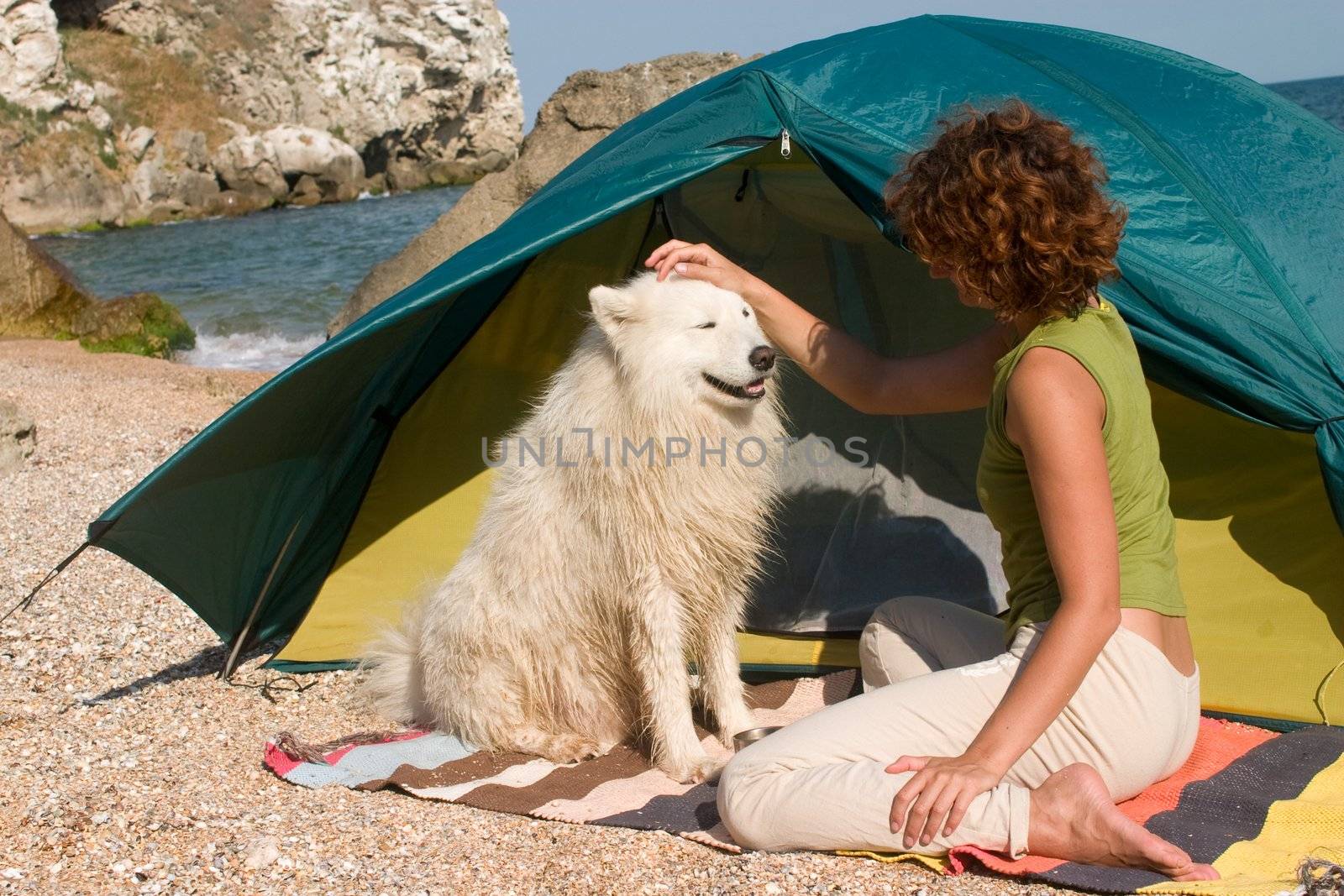 Woman and samoyed dog at seaside