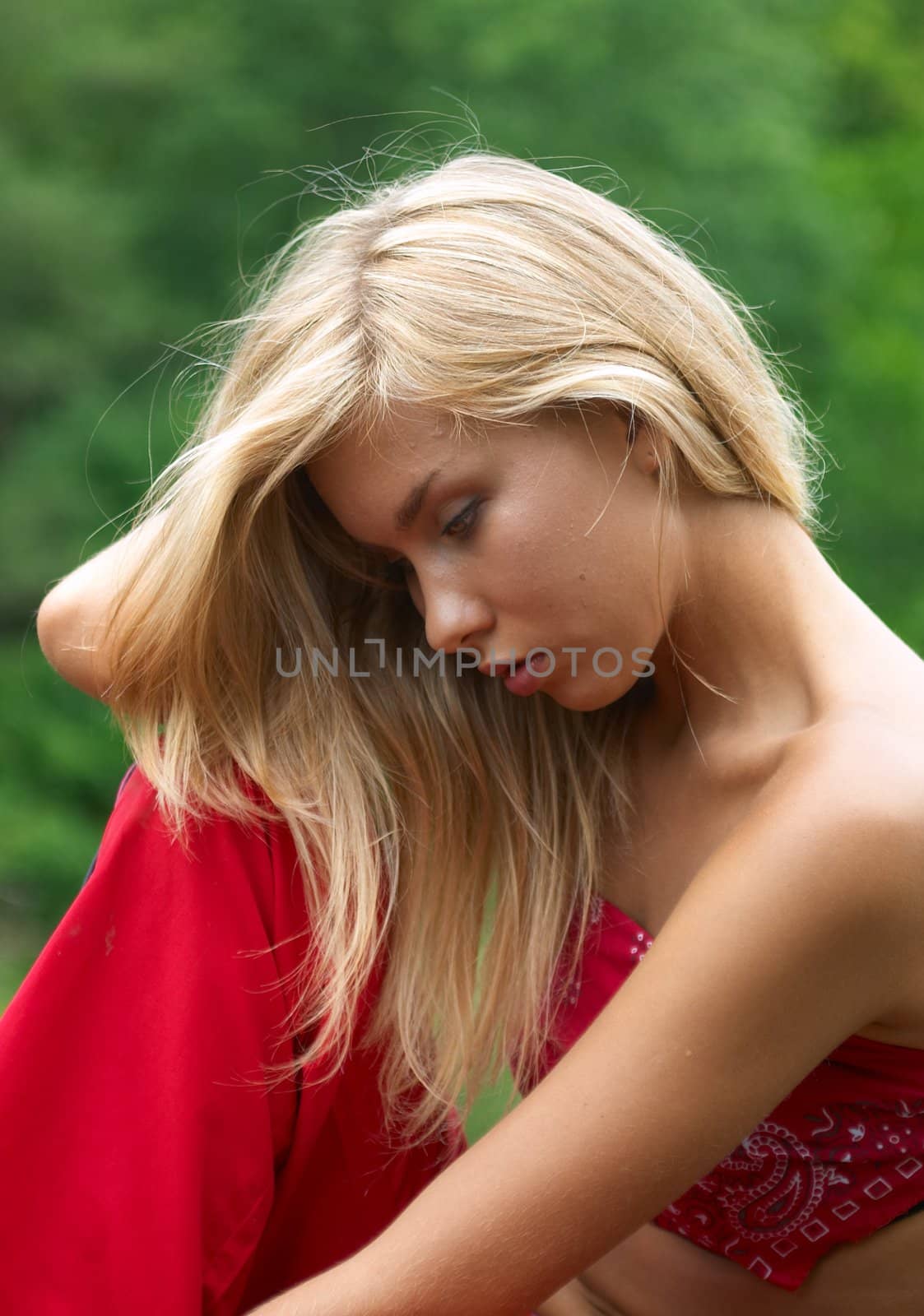 thoughtful girl in red clothes sitting outdoor