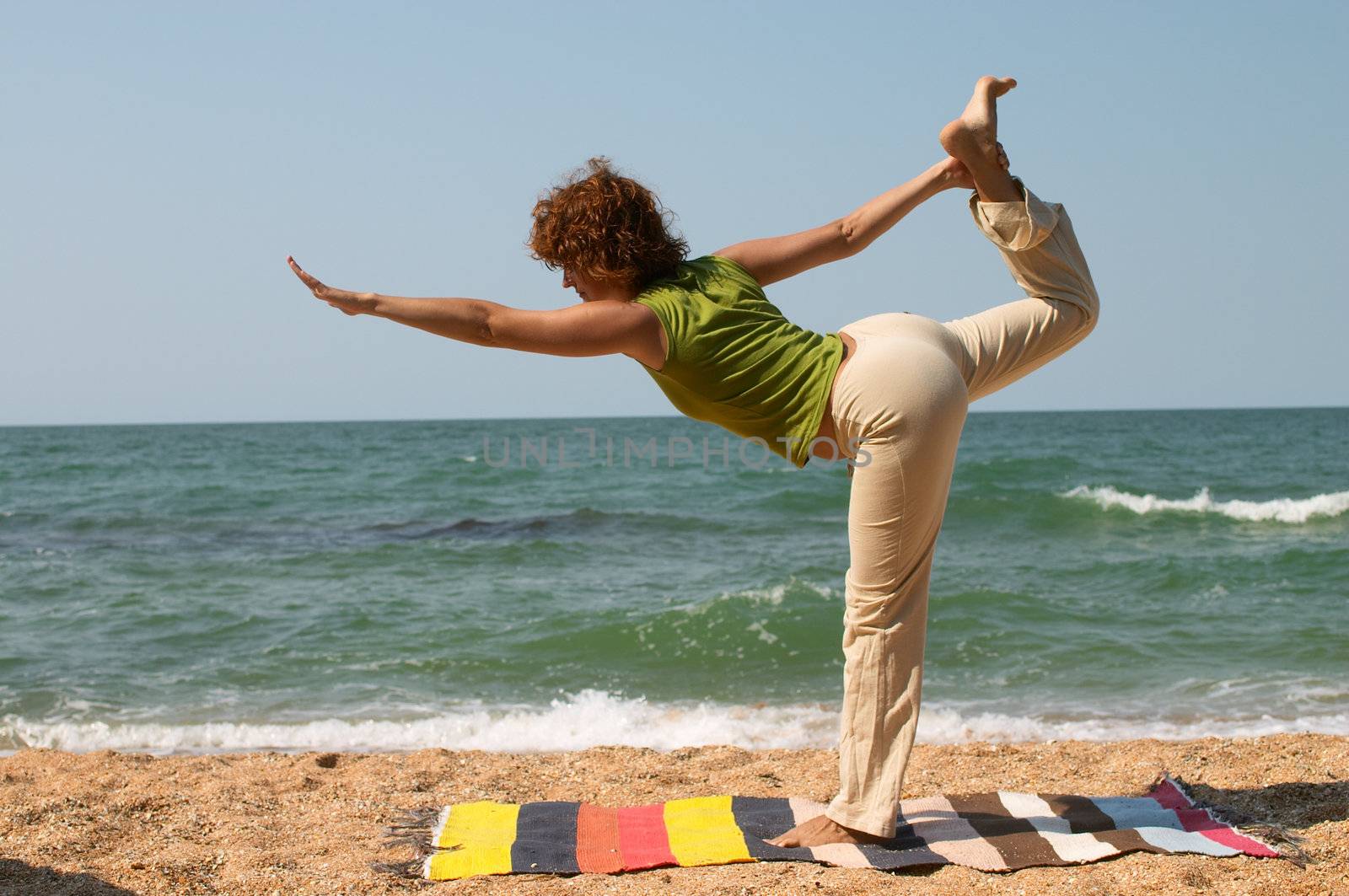 girl doing Natarajasana yoga pose on the seaside