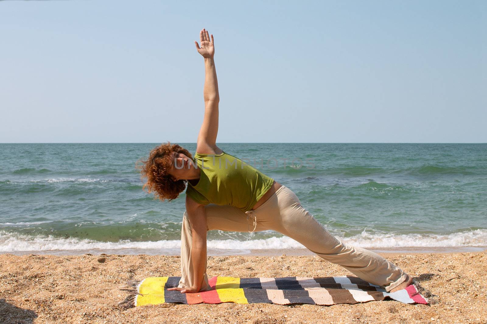 girl in Utthita Parsvakonasana pose at the seaside