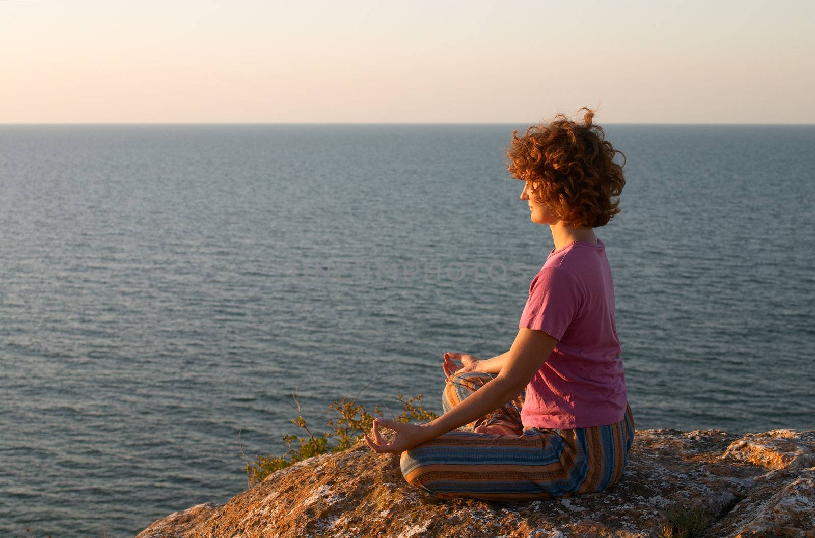 girl meditating on the cliff in padmasana pose