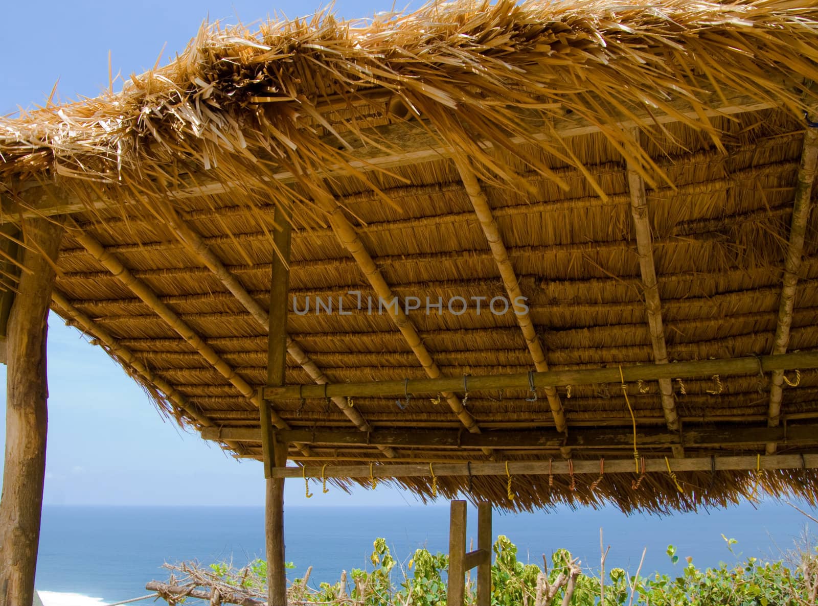 Thatch roof on tropical beach against blue sky