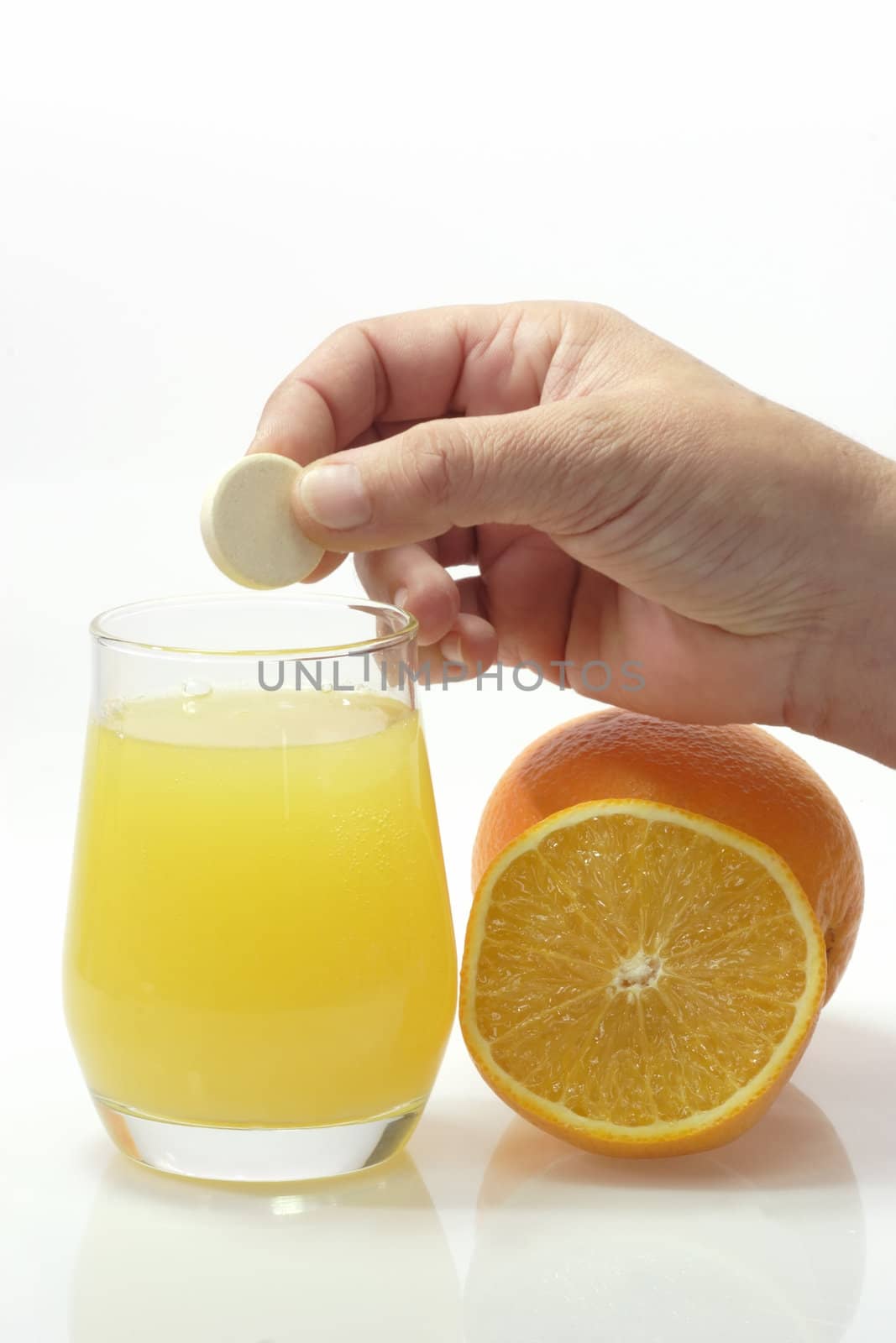 Glas of fizzy liquid with Effervescent tablets on bright background