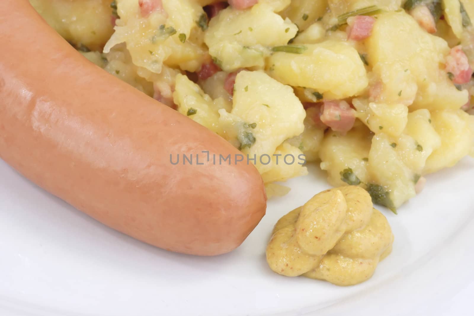 Crisp cooked sausage with potato salad on bright background