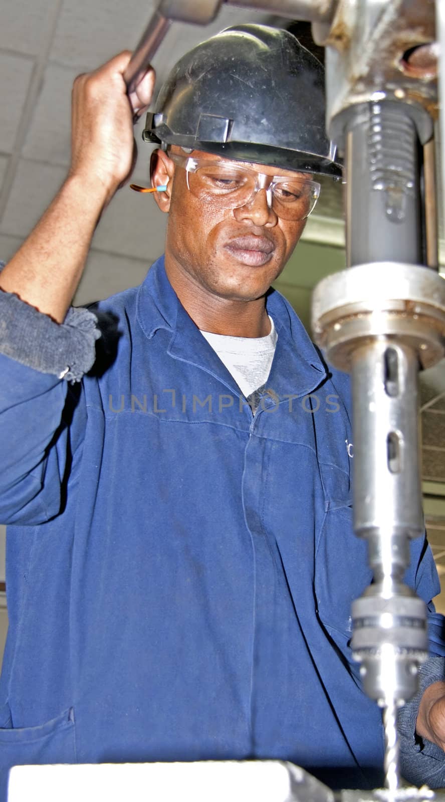 Man drilling with an industrial drill press