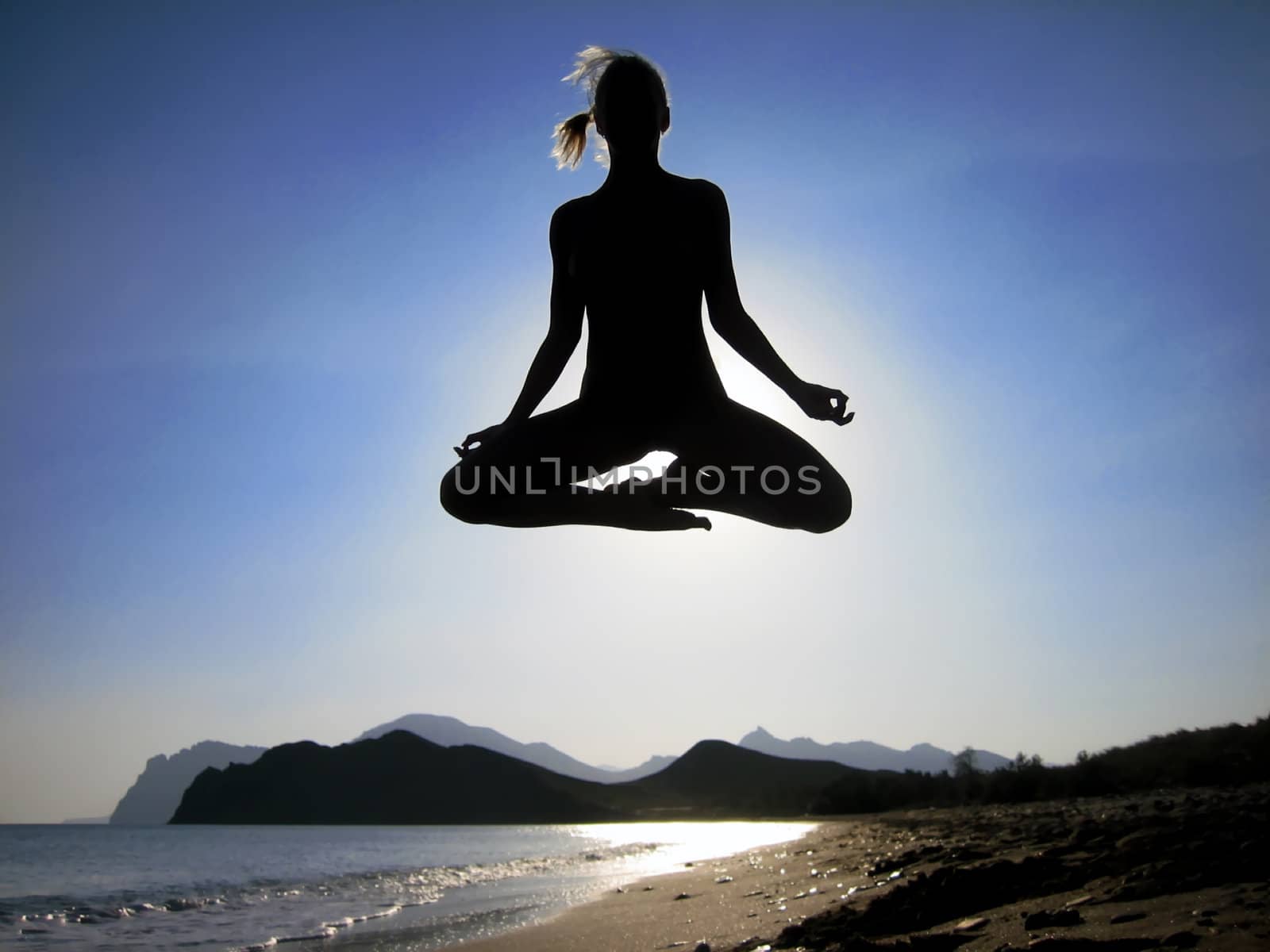 Female yogi flying over the beach