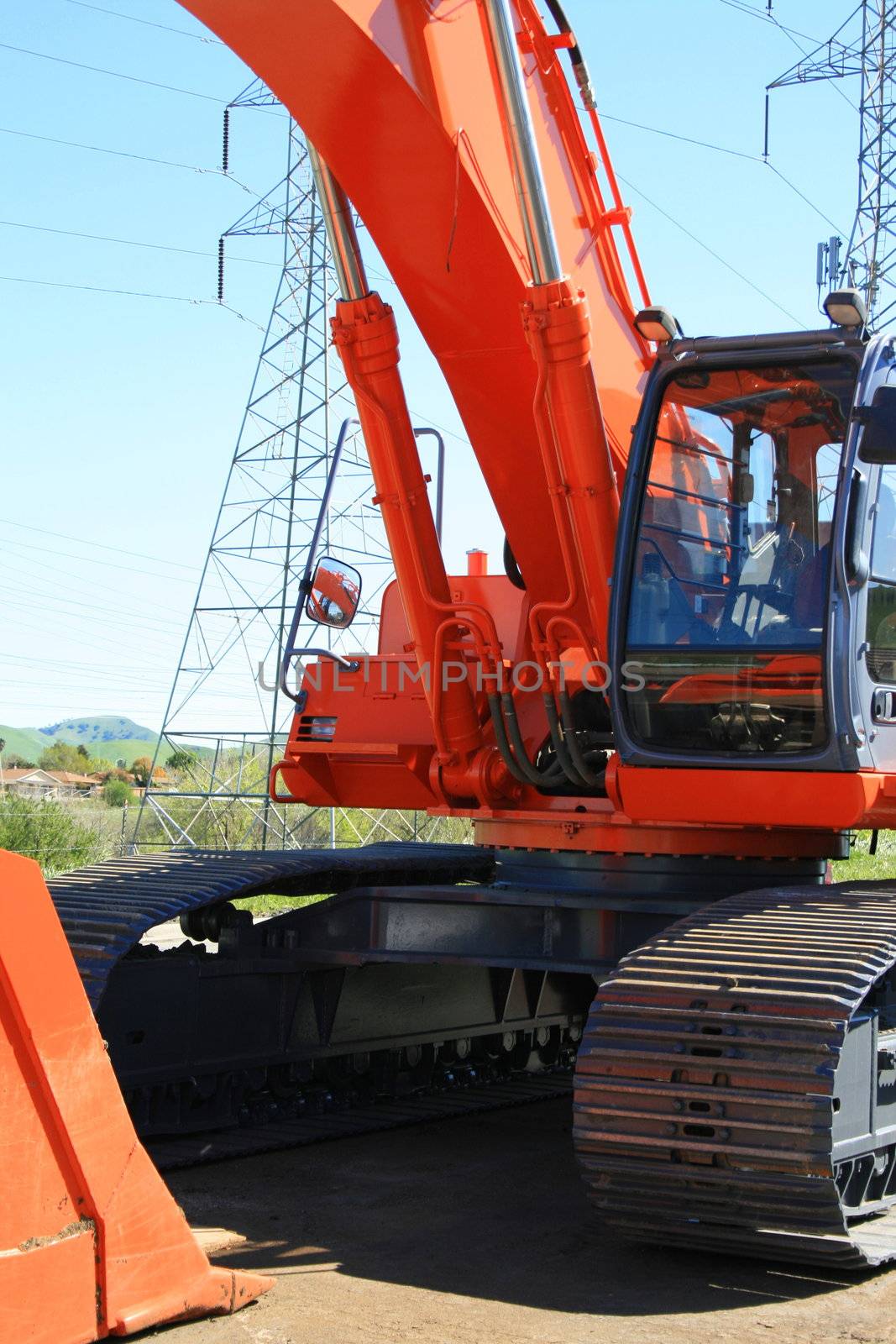 Orange excavator close up on a construction sight.
