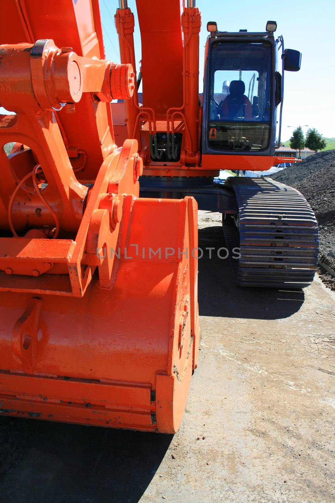 Orange excavator close up on a construction sight.
