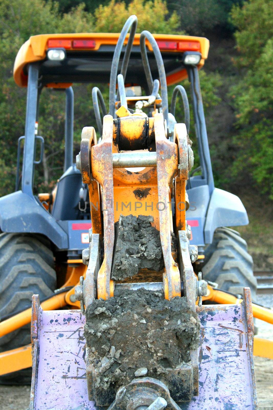 Yellow excavator close up on a construction sight.
