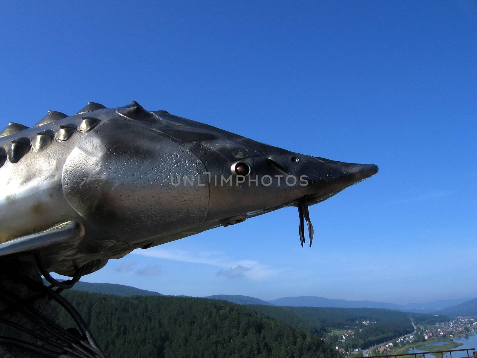 Metal statue of sturgeon on a background of blue sky