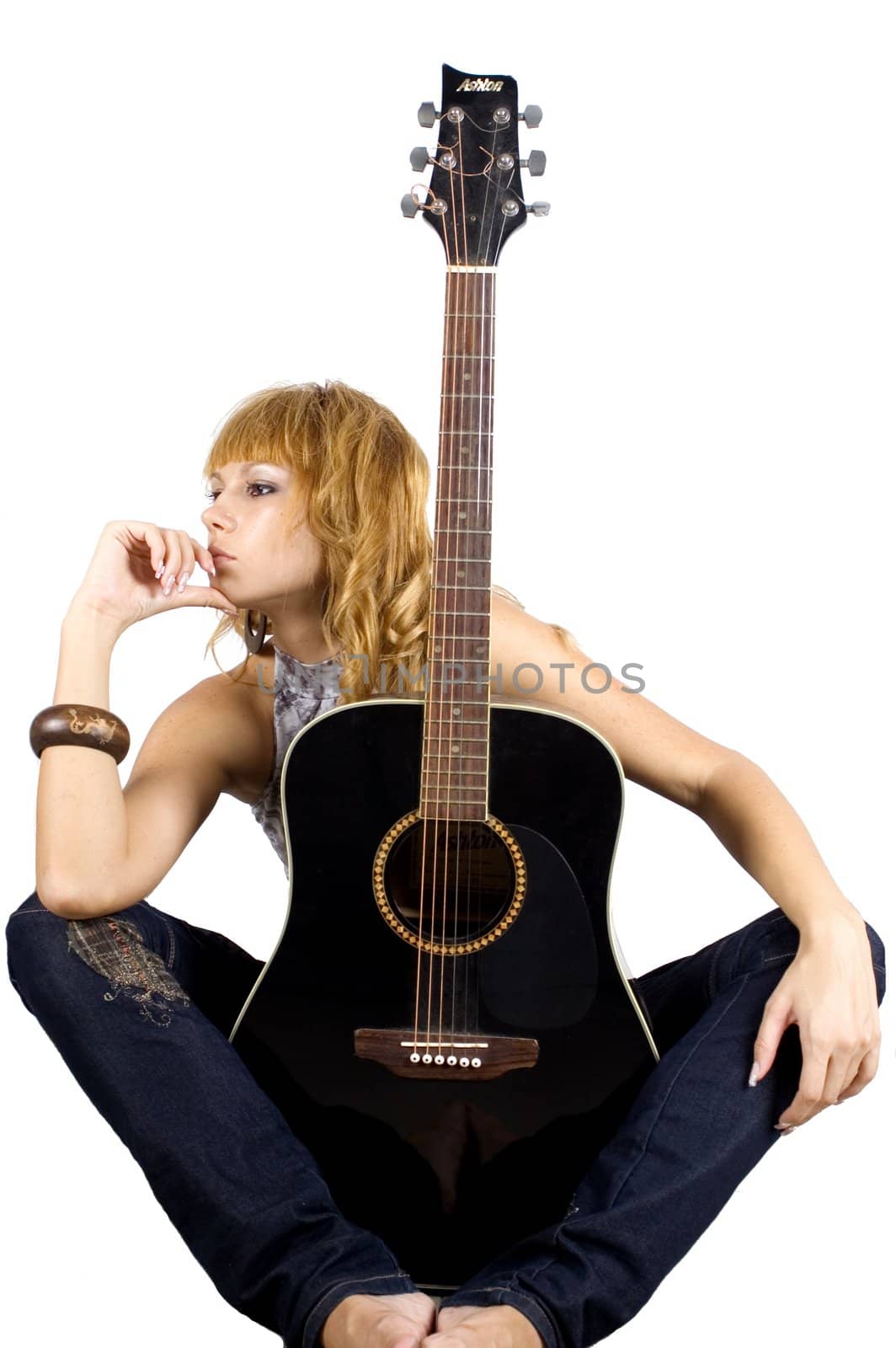 Sitting with guitar. Young, pretty musician is sitting with guitar.