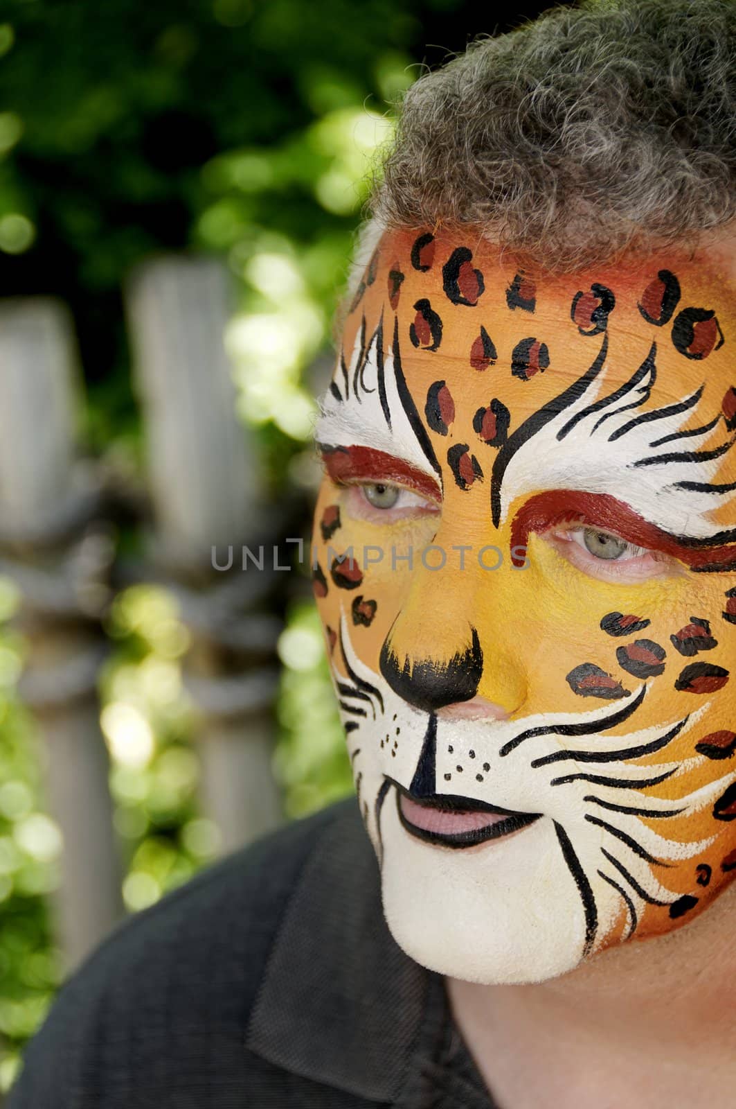 A man with his face painted to look like a leopard.