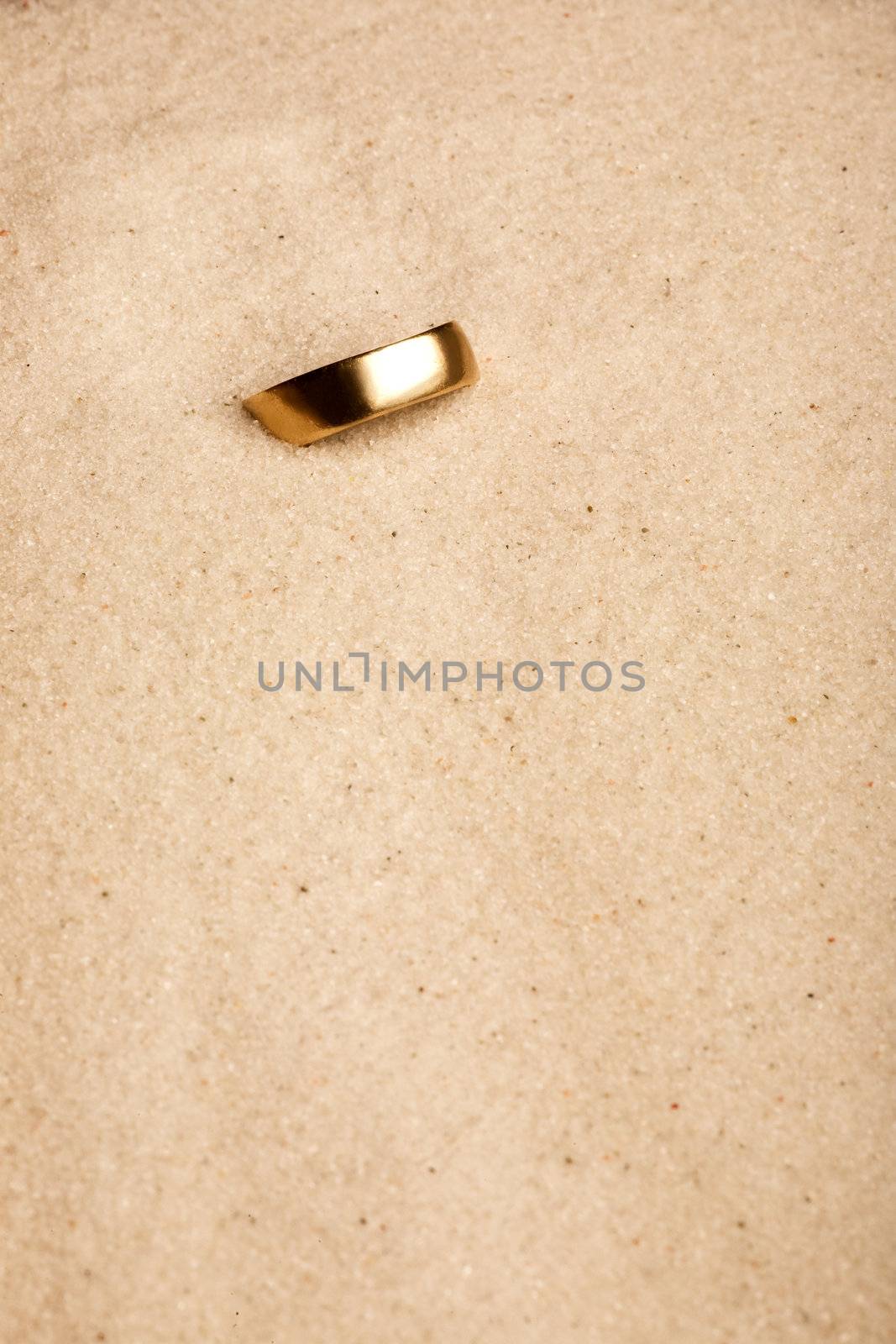 A wedding ring buried in the sand - lost