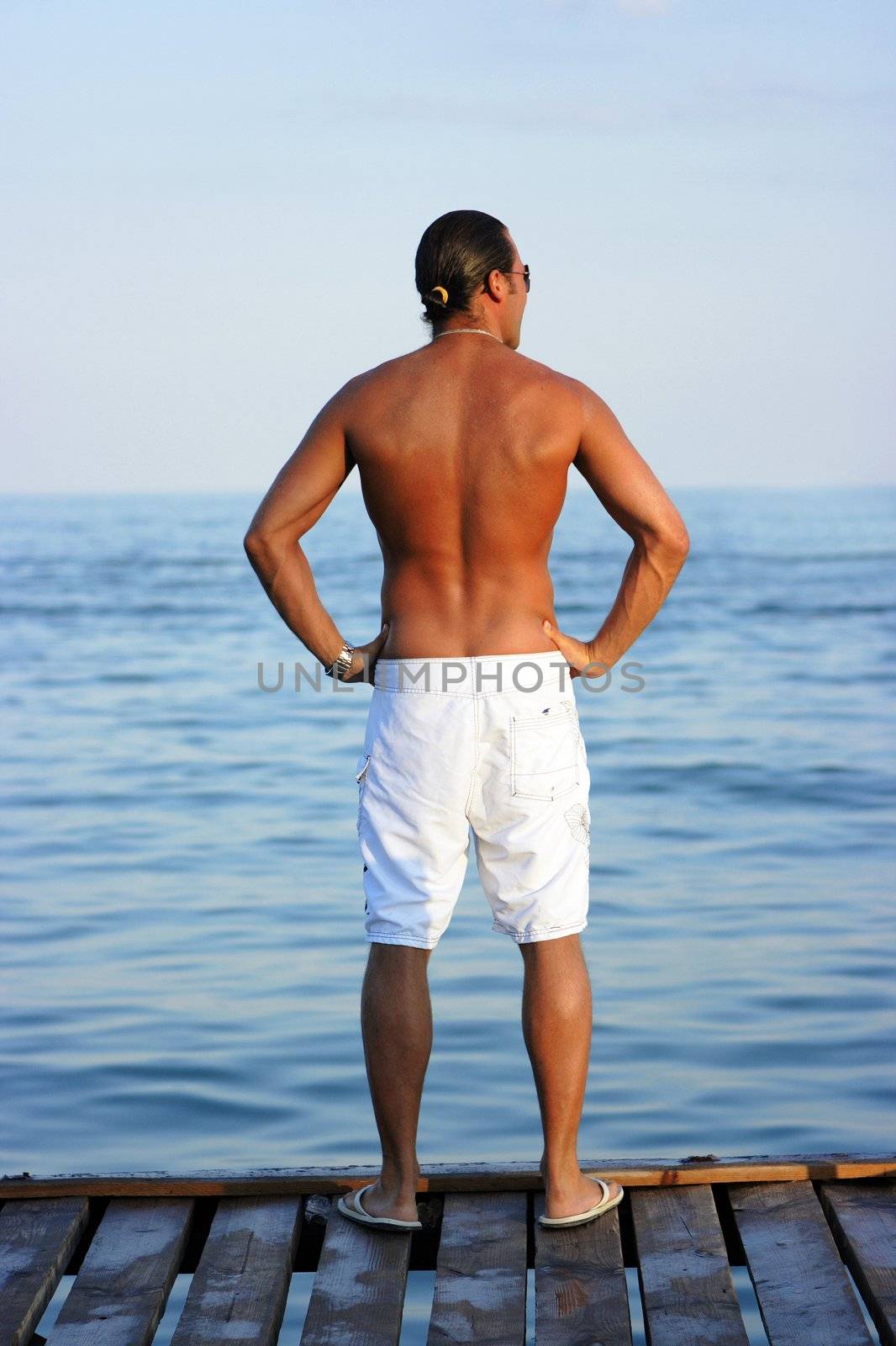 Handsome man stading alone on the pierce