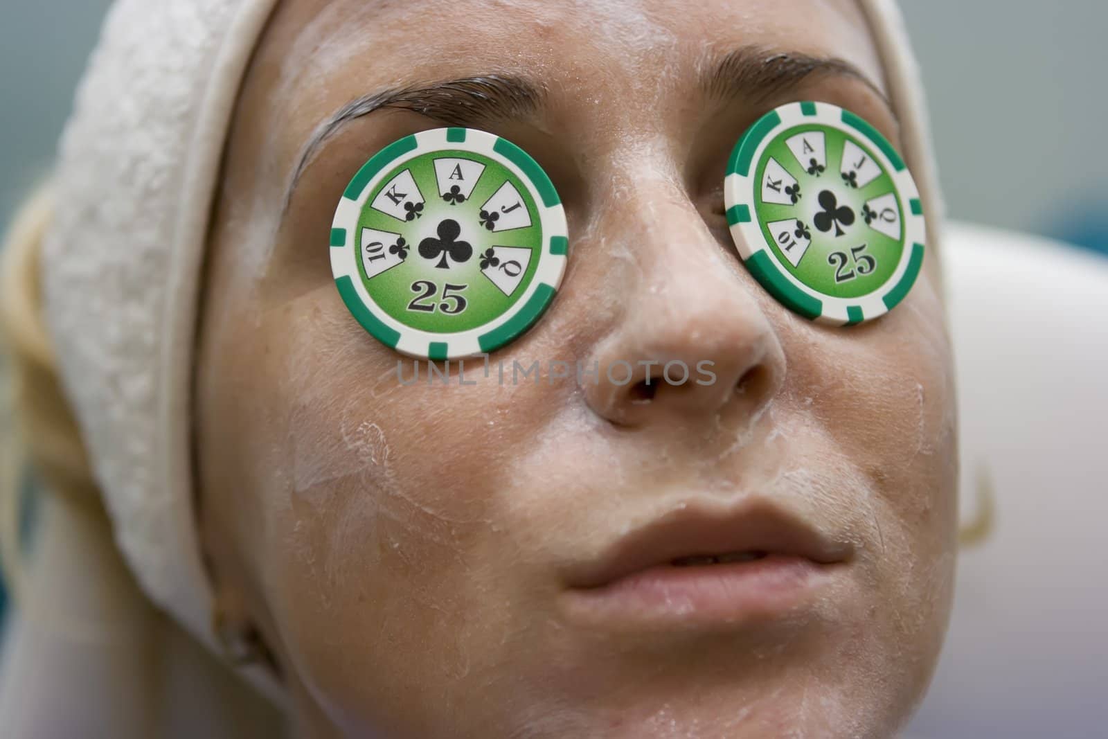 Poker chips lying on eyes like cucumbers in spa salon