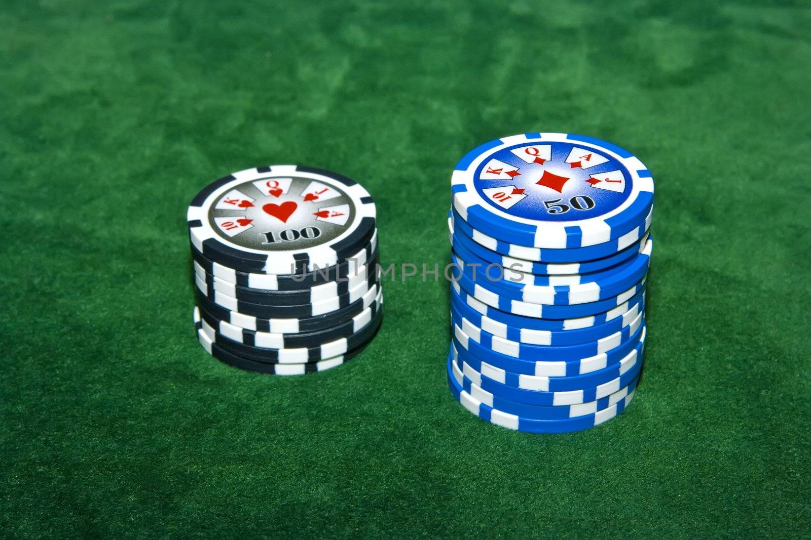 Poker table with 50 and 100 dollar chips on it