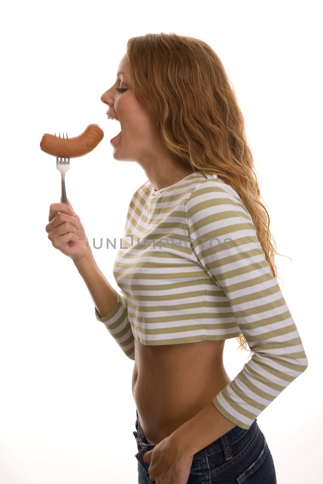 red-haired girl eating a sausage on a light background