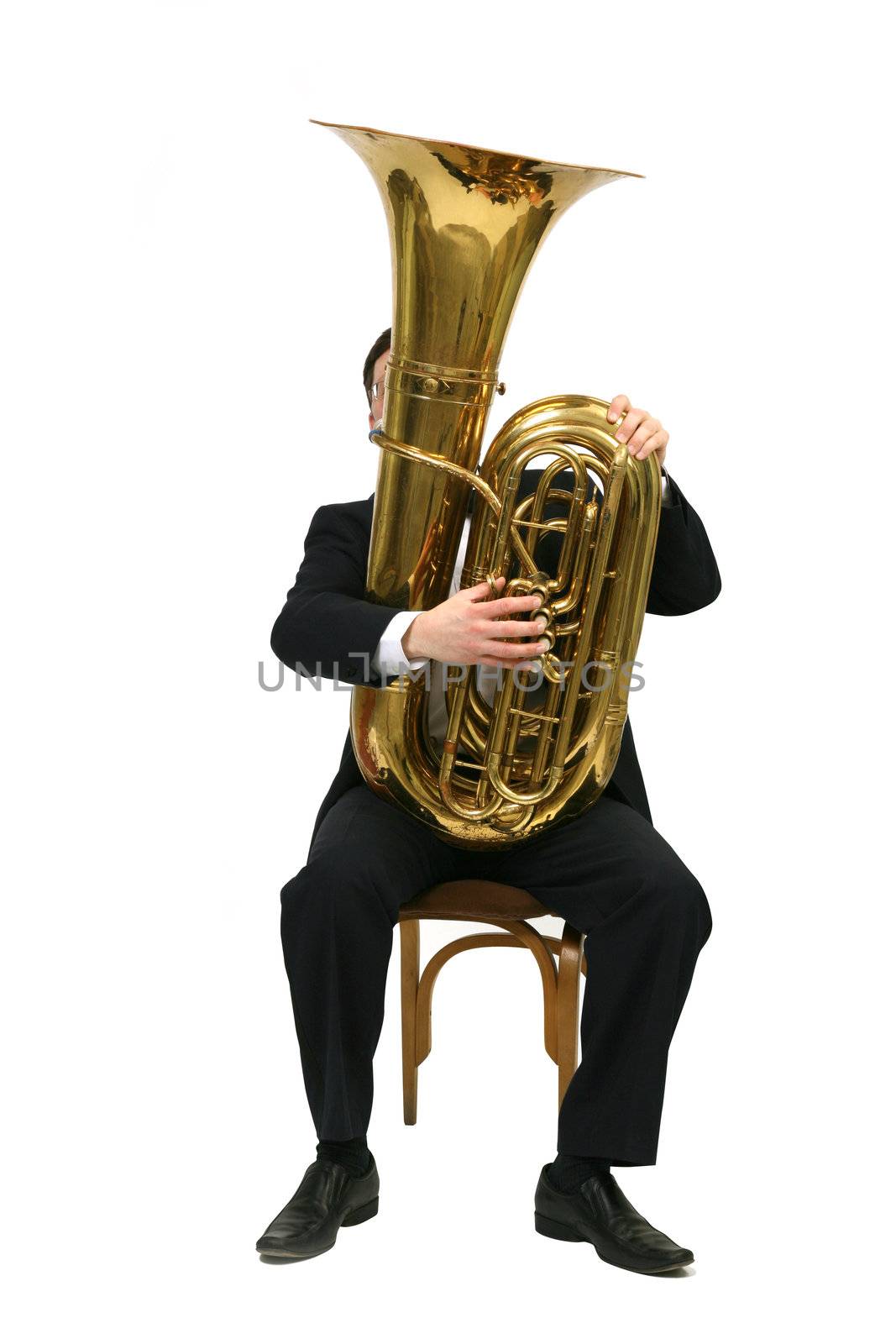 man sitting on a chair and plays the tuba