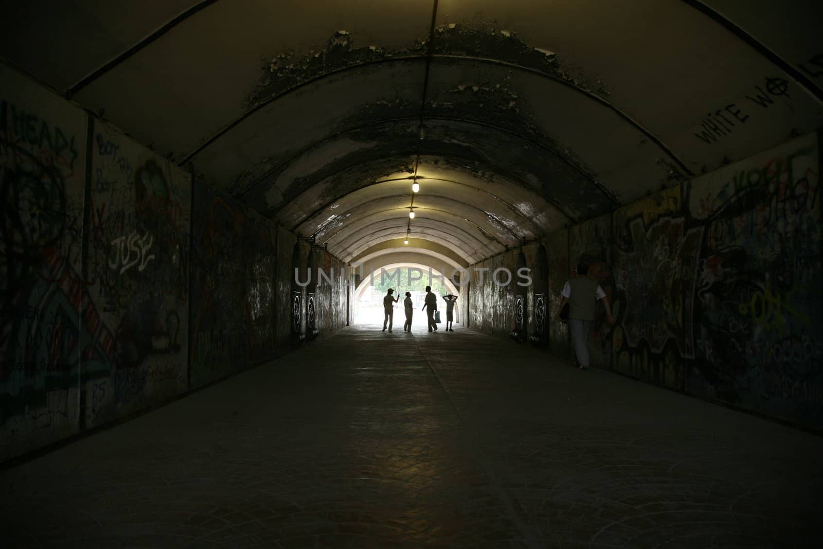 Several people are walking in the underpass