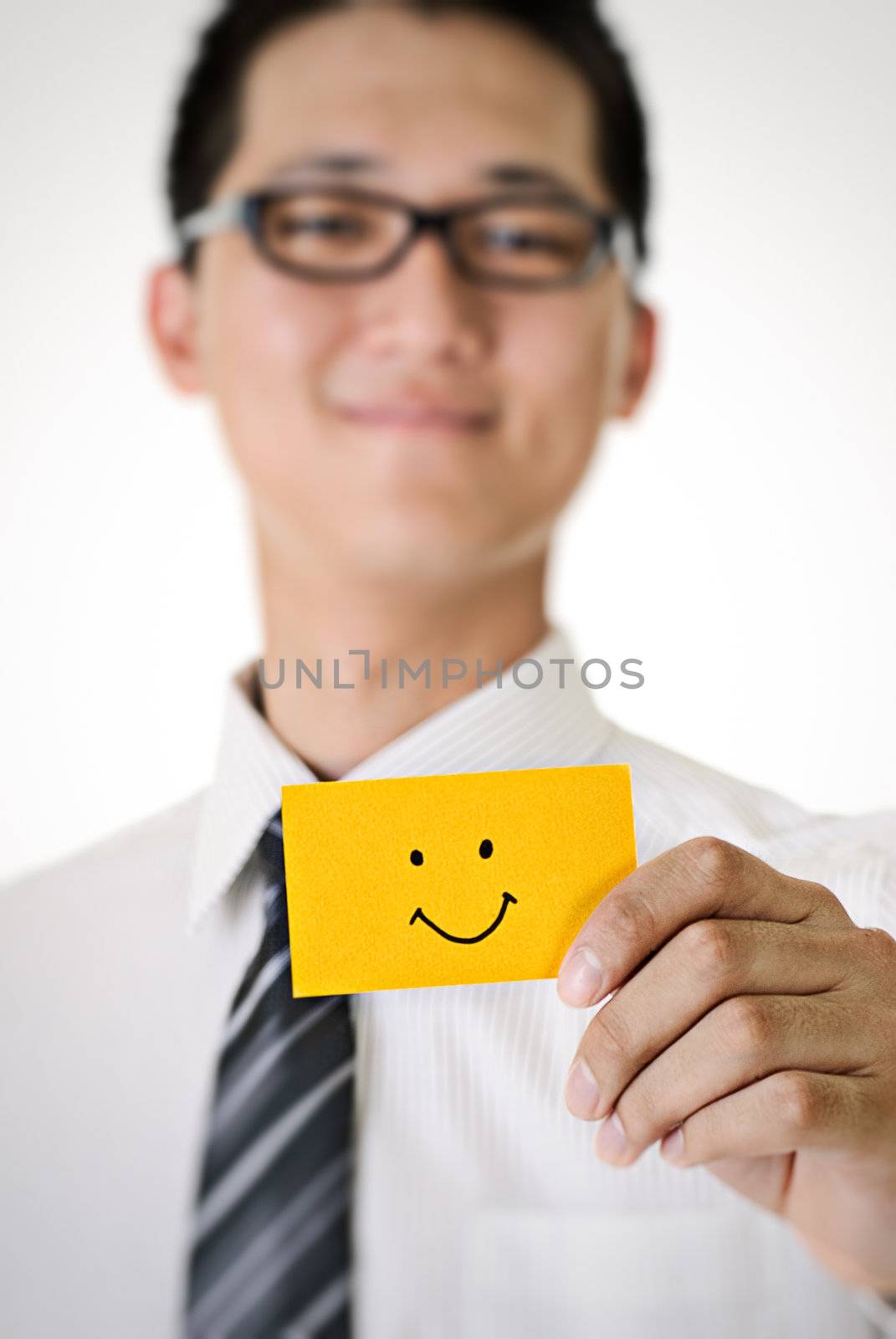 Smile pattern on yellow card hold by business man.
