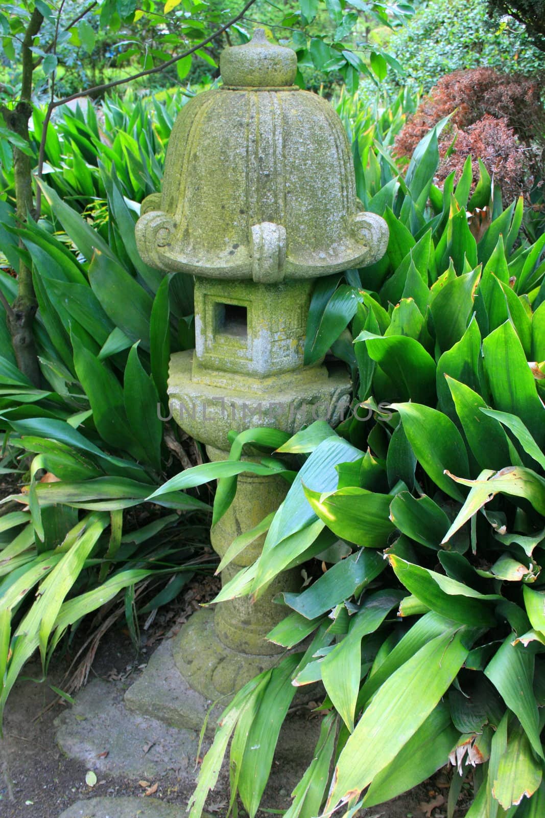 Close up of a japanese statue in a garden.
