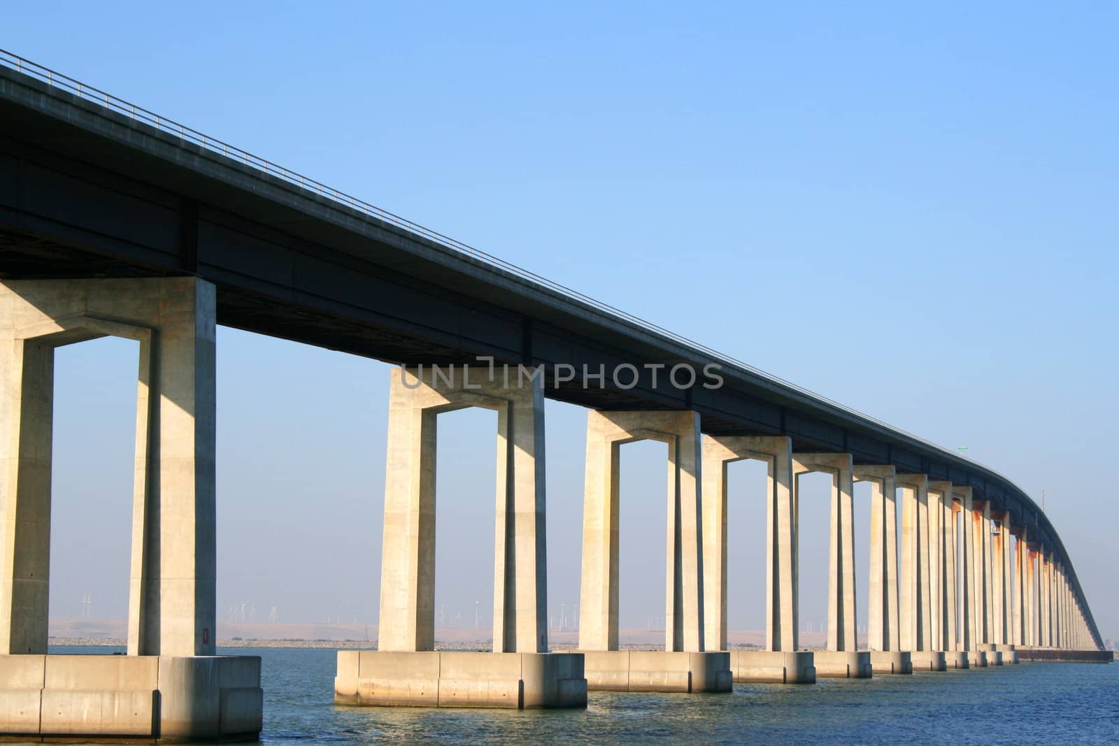 Long modern bridge built over a river.
