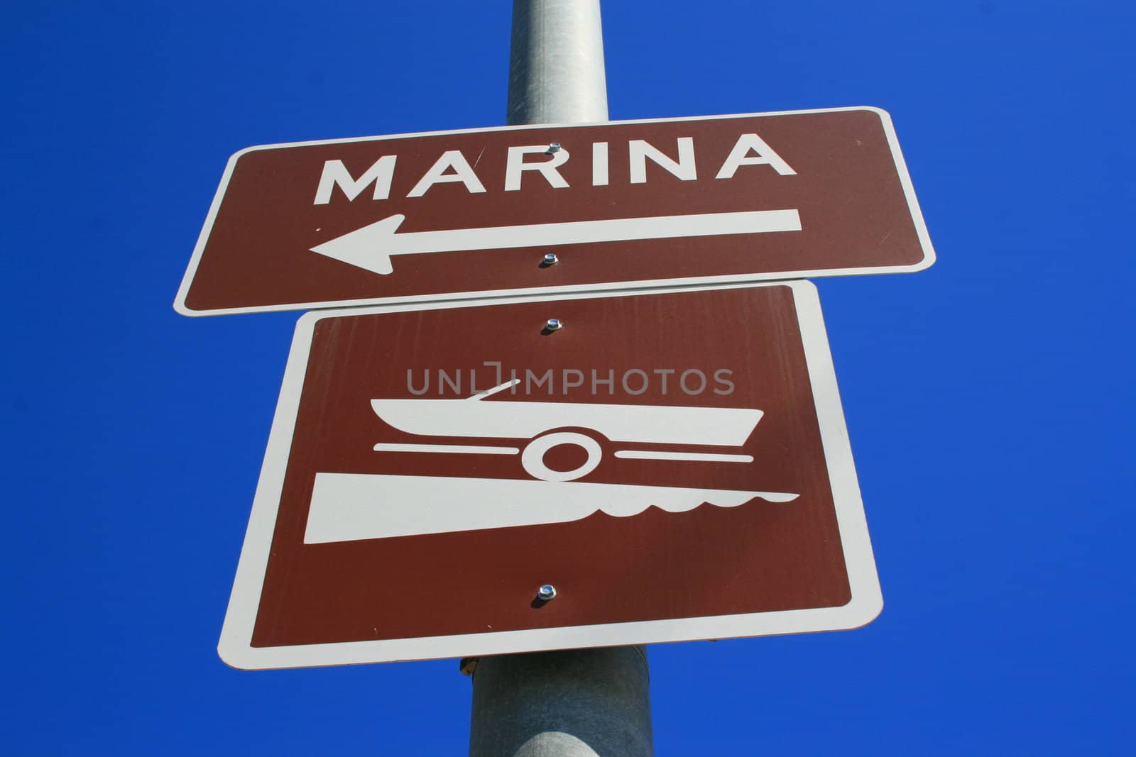 Marina direction street sign over blue sky.
