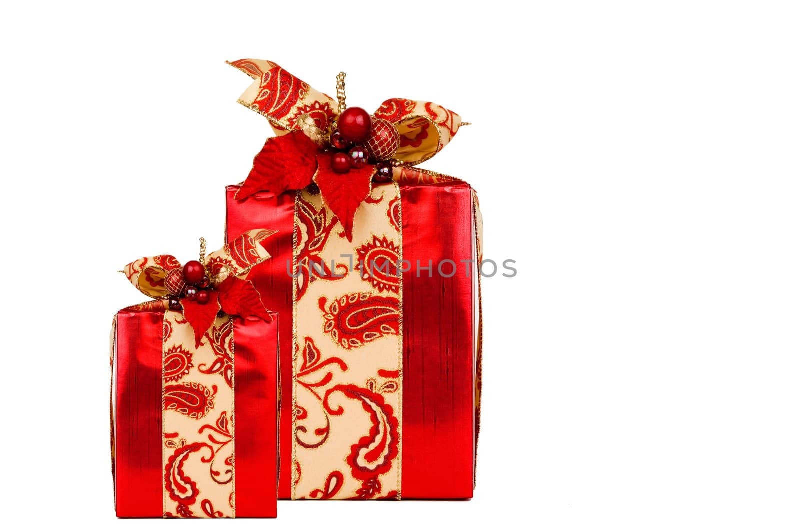 Two red holiday presents beautifully decorated with ribbon and adornments. Clipping path included.