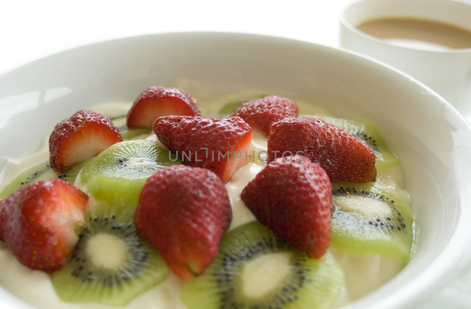 Fruit yoghurt and a cup of tea with a high key background