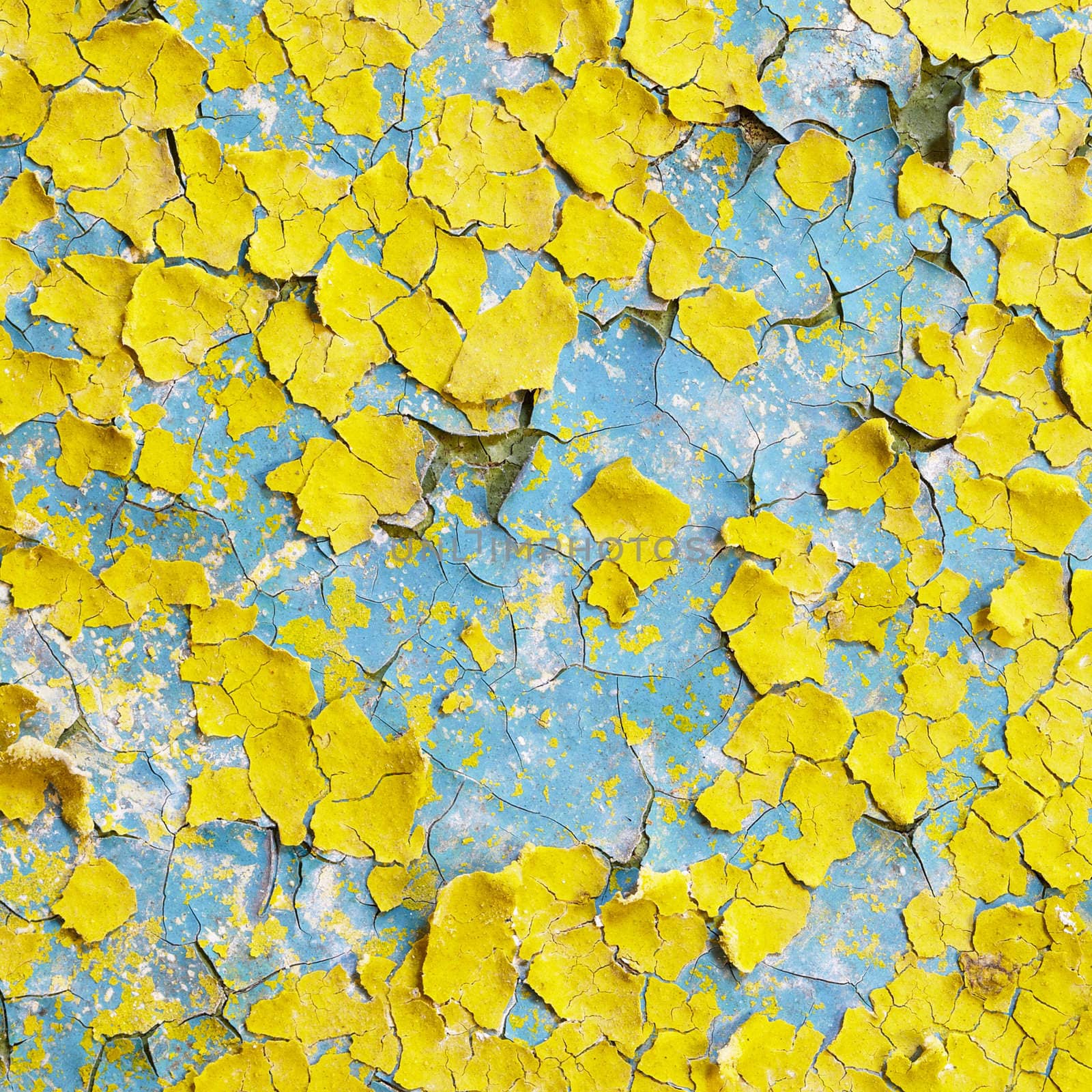 Yellow wall covered with scraps of an old paint