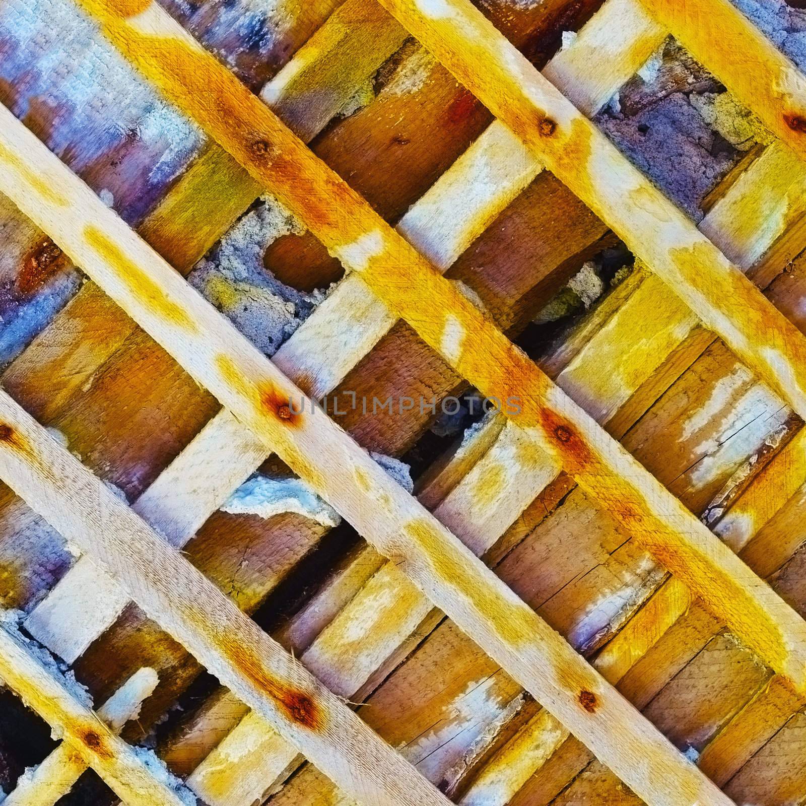 The damaged ancient wall with the bared wooden skeleton