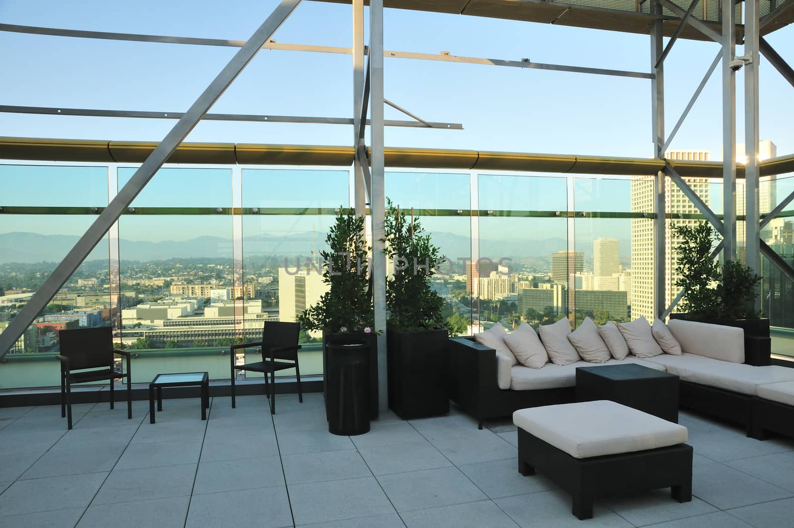 Chairs and a couch provide a place to enjoy the downtown sunset from a highrise rooftop