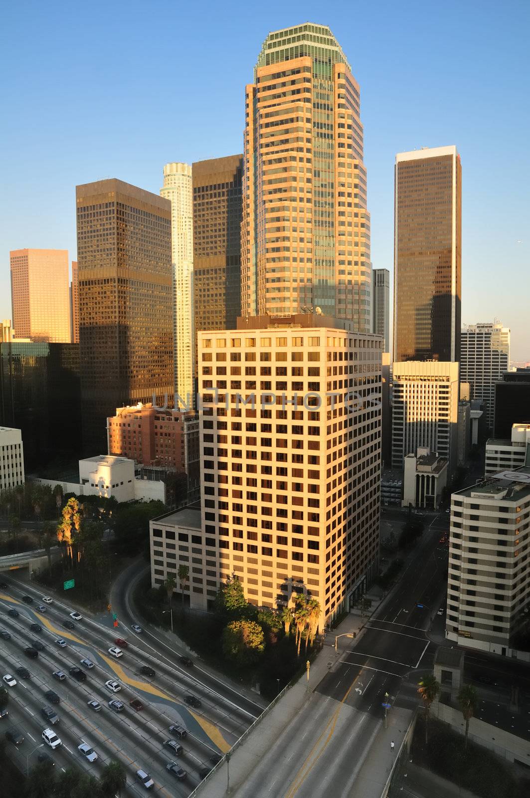 Los Angeles highrises over a busy freeway at sunset