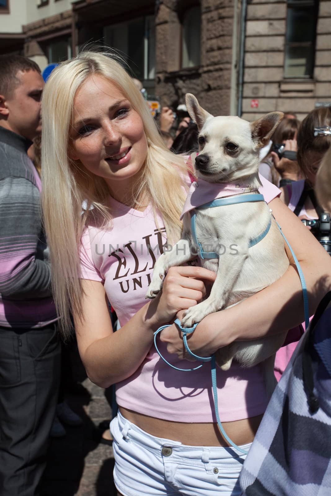 RIGA, LATVIA - MAY 29: A girl poses with her dog during the "Go Blonde" parade Organized by the Latvian Association of Blonds in May 29, 2010, Riga.