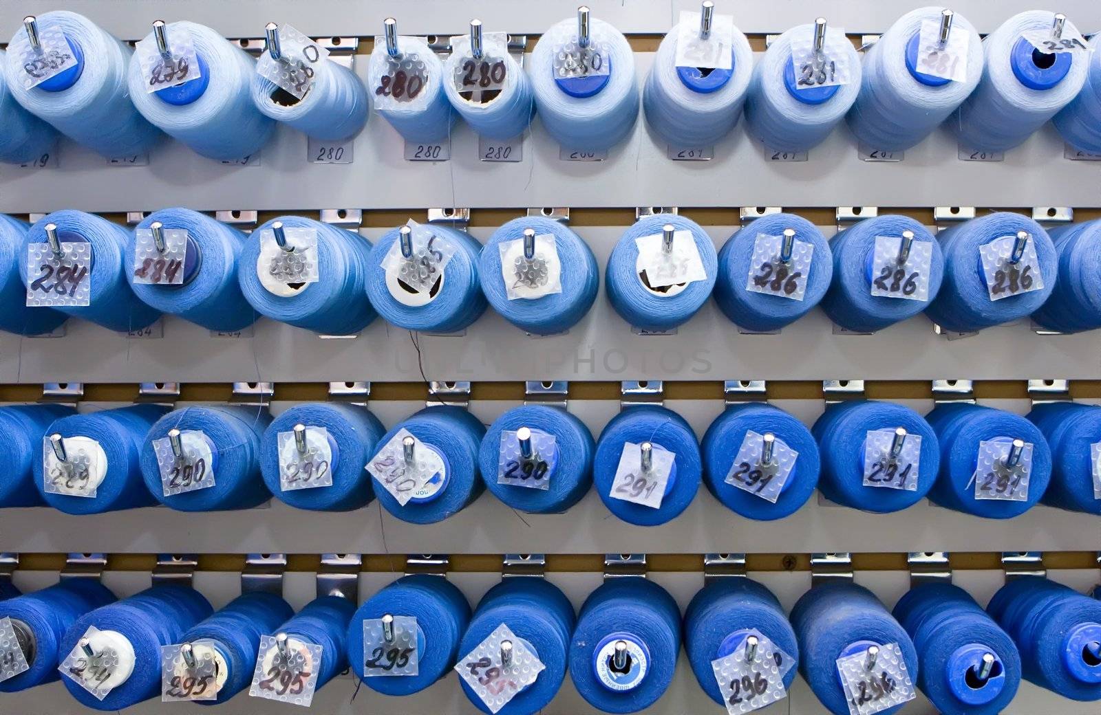 A lot of thread spools attached to a wall