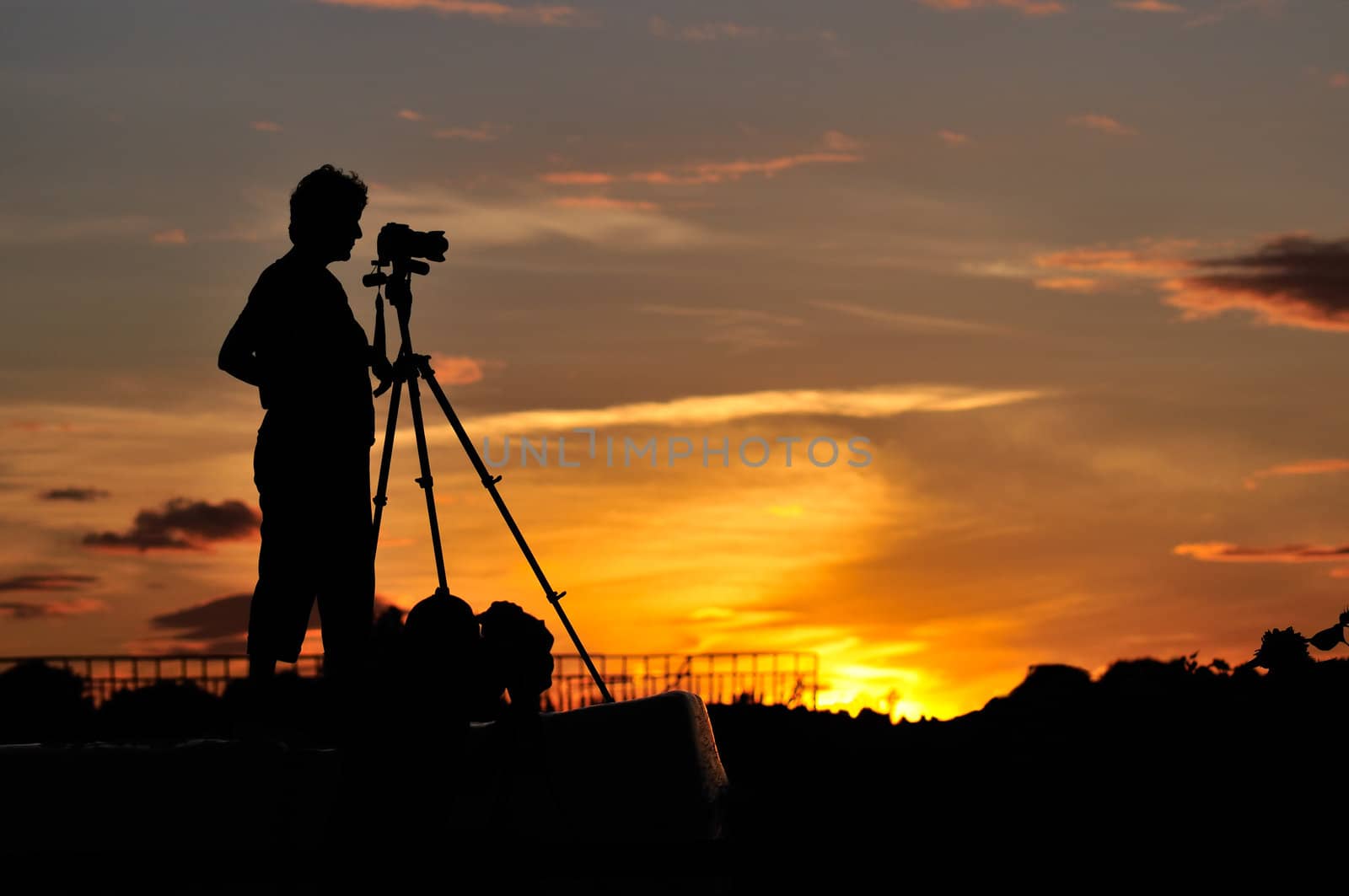 Silhouette of a photographer shooting sunset scene