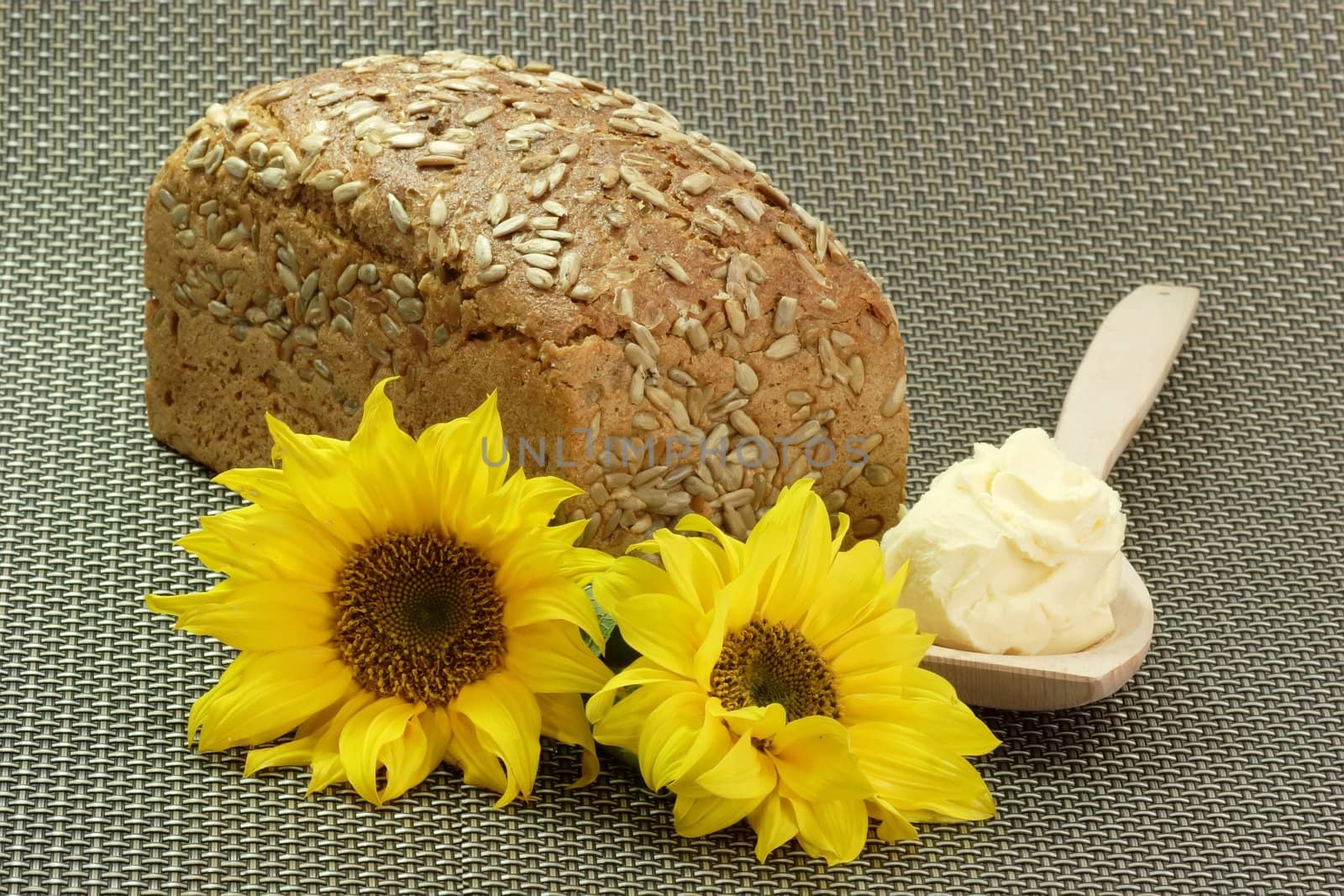 Bread with Oleo on a Cooking Spoon and Sunflowers