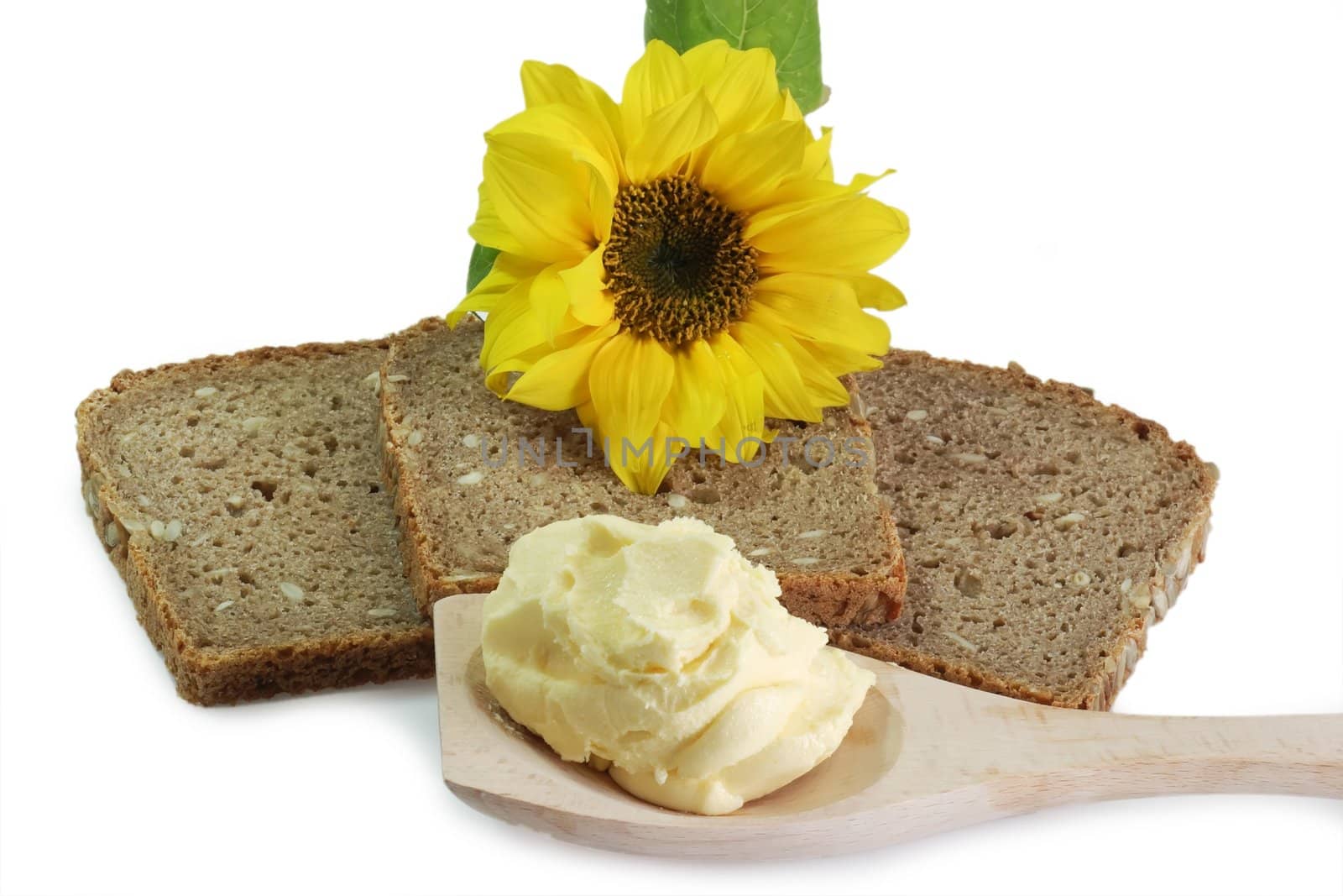 Brown bread with oleo on a cooking spoon and sunflower