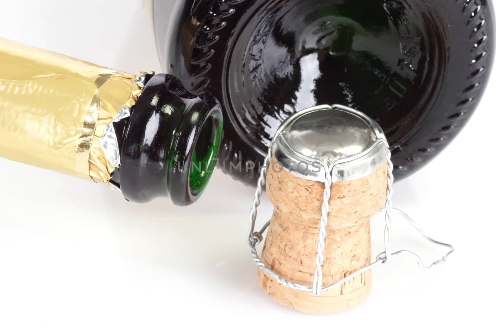 Empty champagne bottles and corks on white background