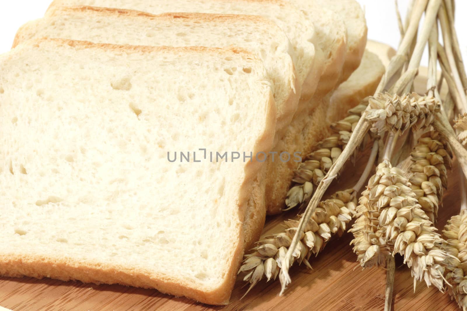 Toast slices and wheat ears on a kitchen board