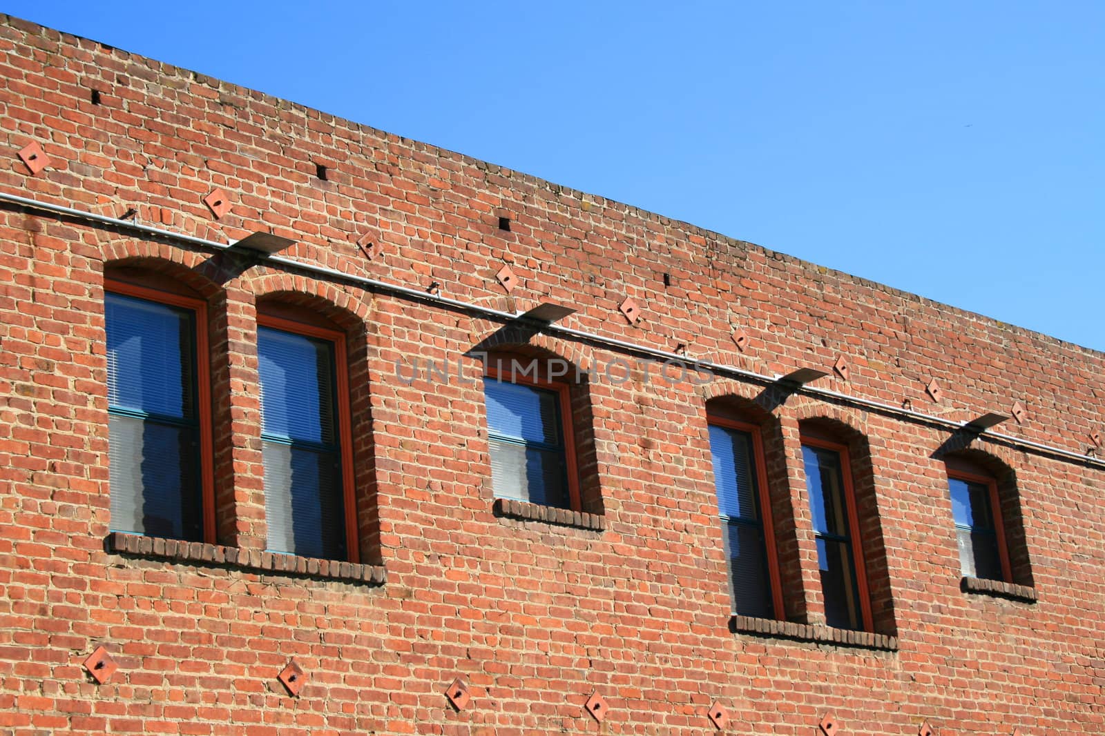 Old red brick building over blue sky.
