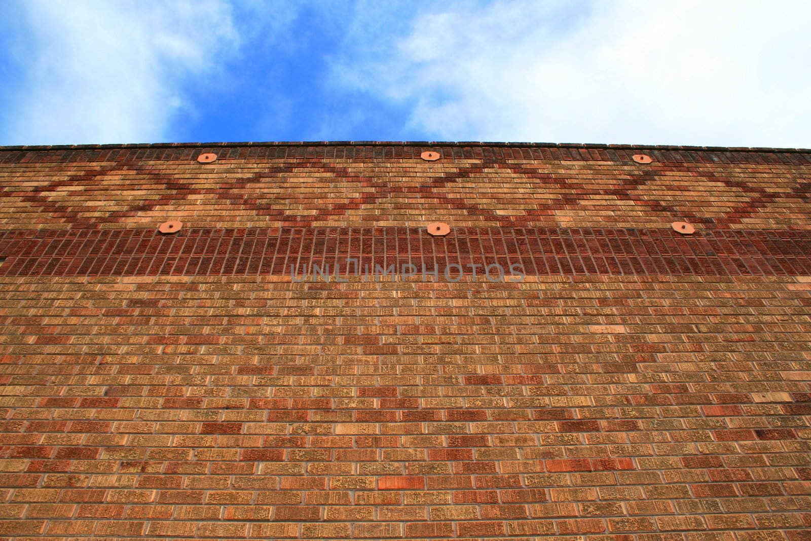 Brickwall over blue sky showing unique pattern.
