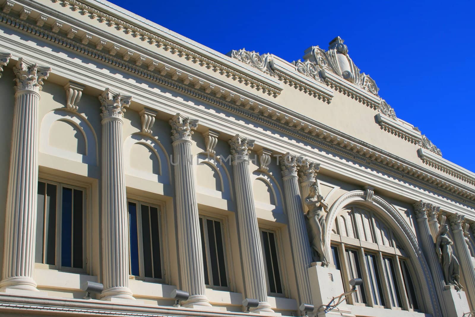 Row of columns and statues showing unique architecture of a historic building.
