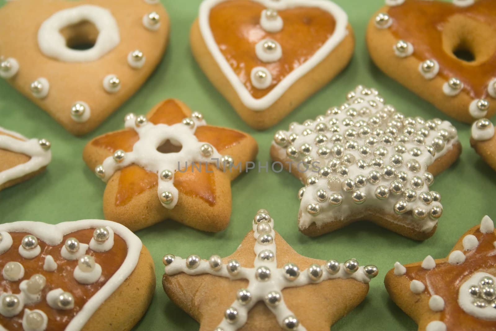 Decorated star and heart cookies on green paper