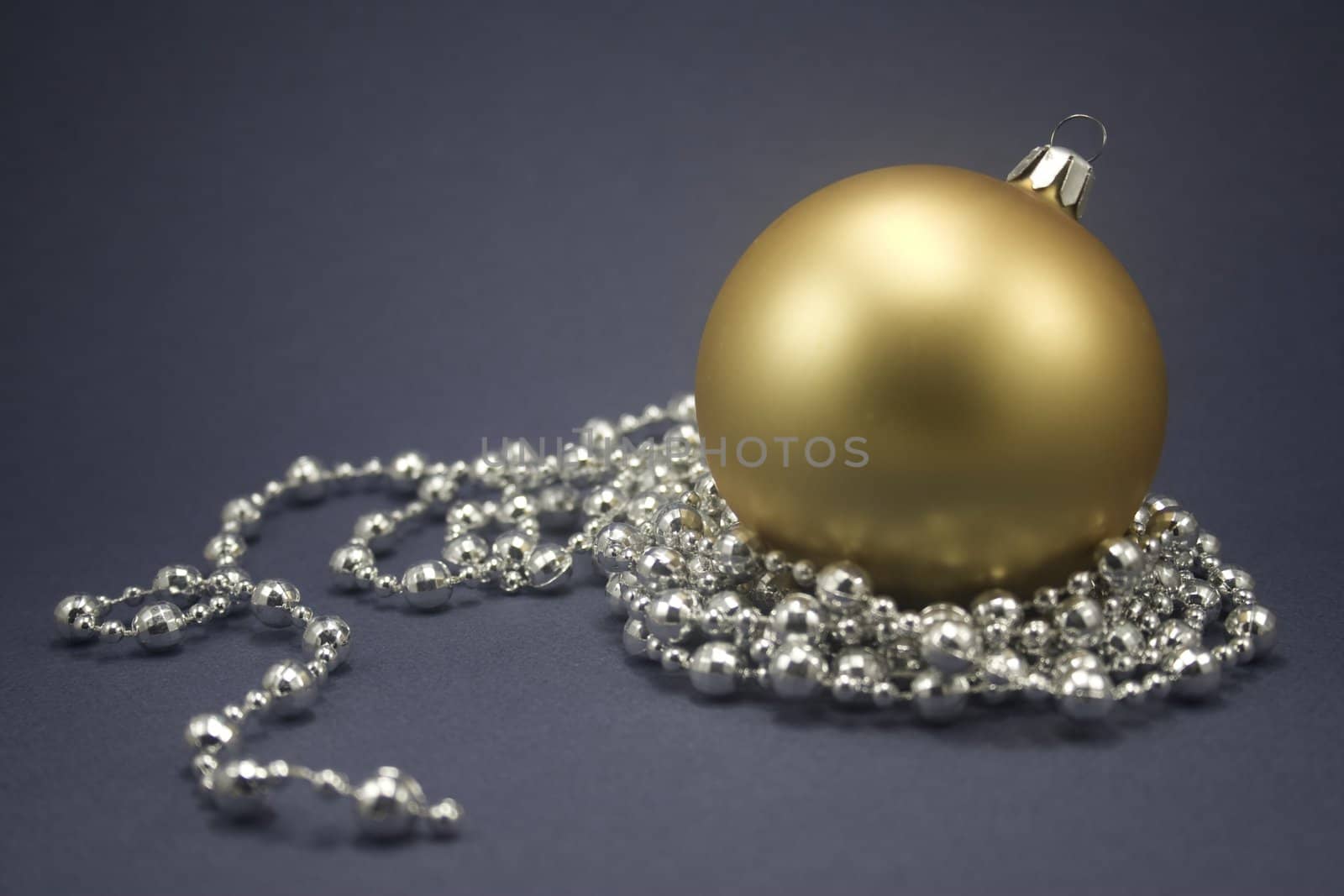 Single ornament with silver beaded string isolated on blue paper