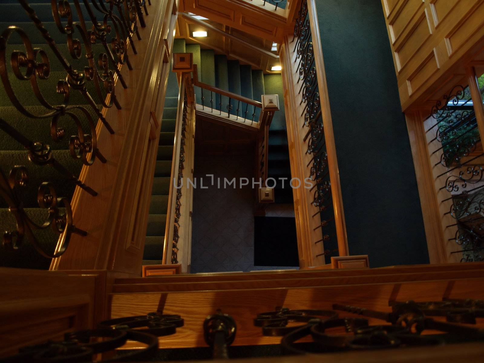 An interior stairway in an office building. Wood and wrought iron railings.